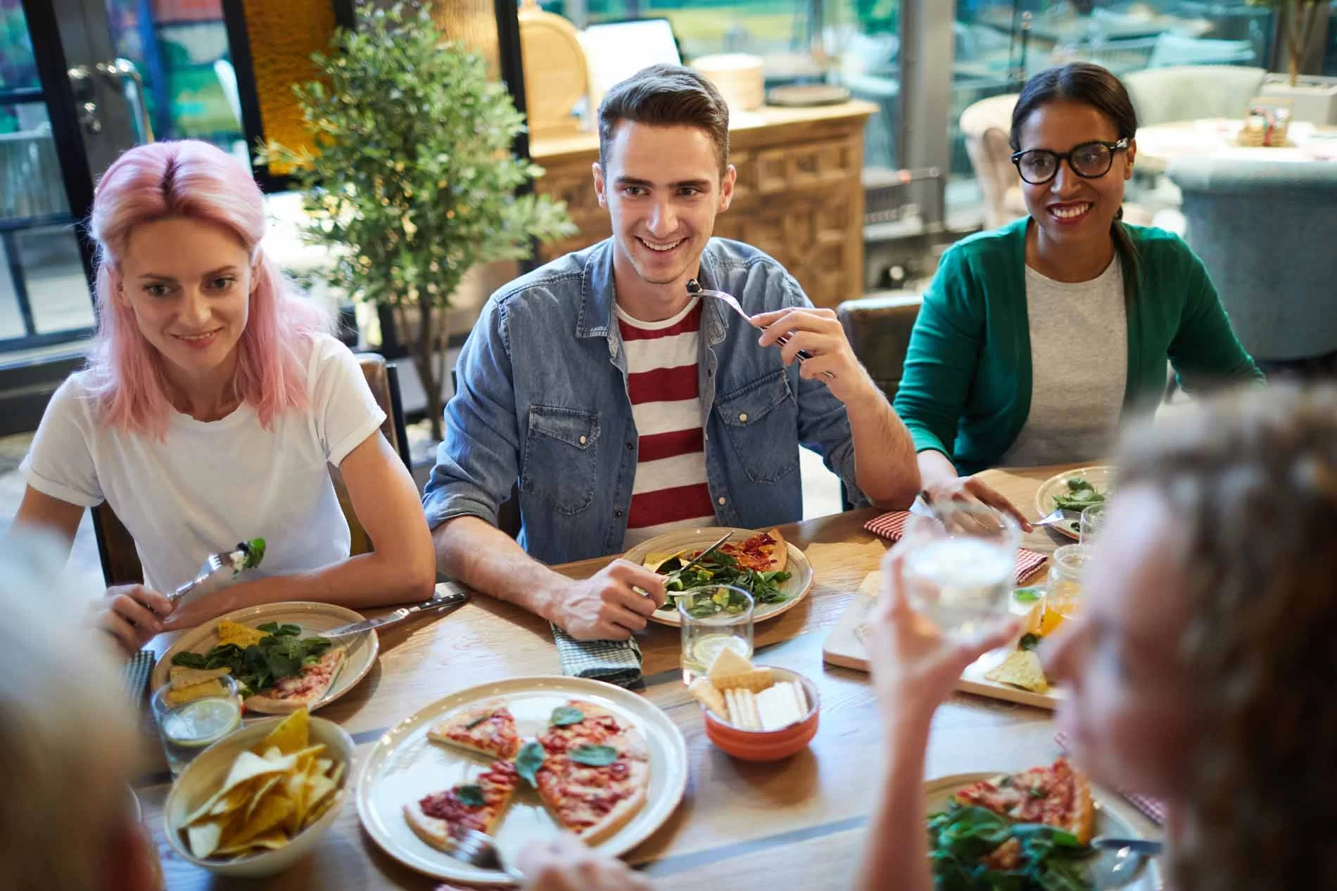 Ihmisiä lounastamassa pöydän ääressä ravintolassa